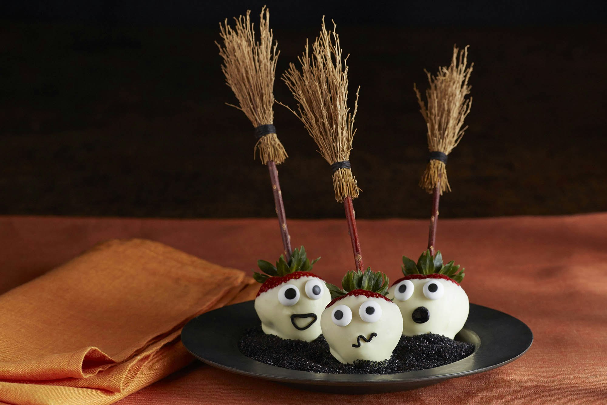 Three strawberries decorated as ghosts with tony brooms 